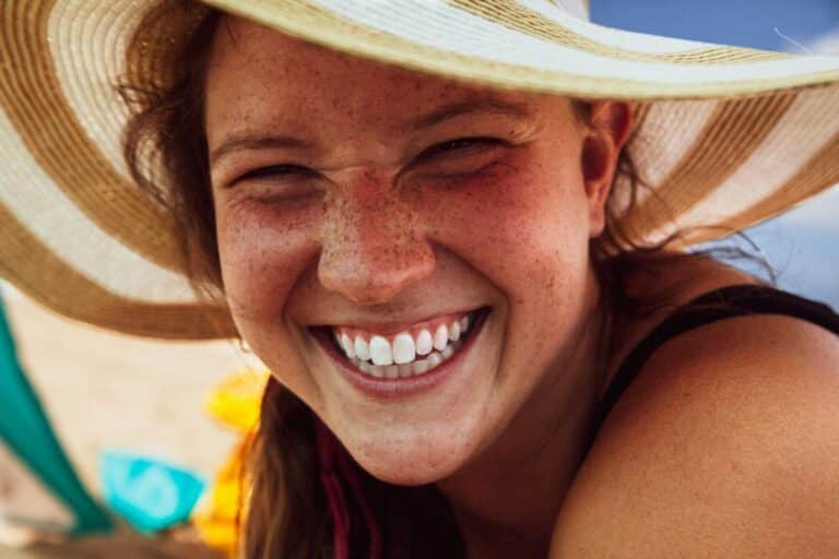 une femme souriante avec un chapeau sur la tête.