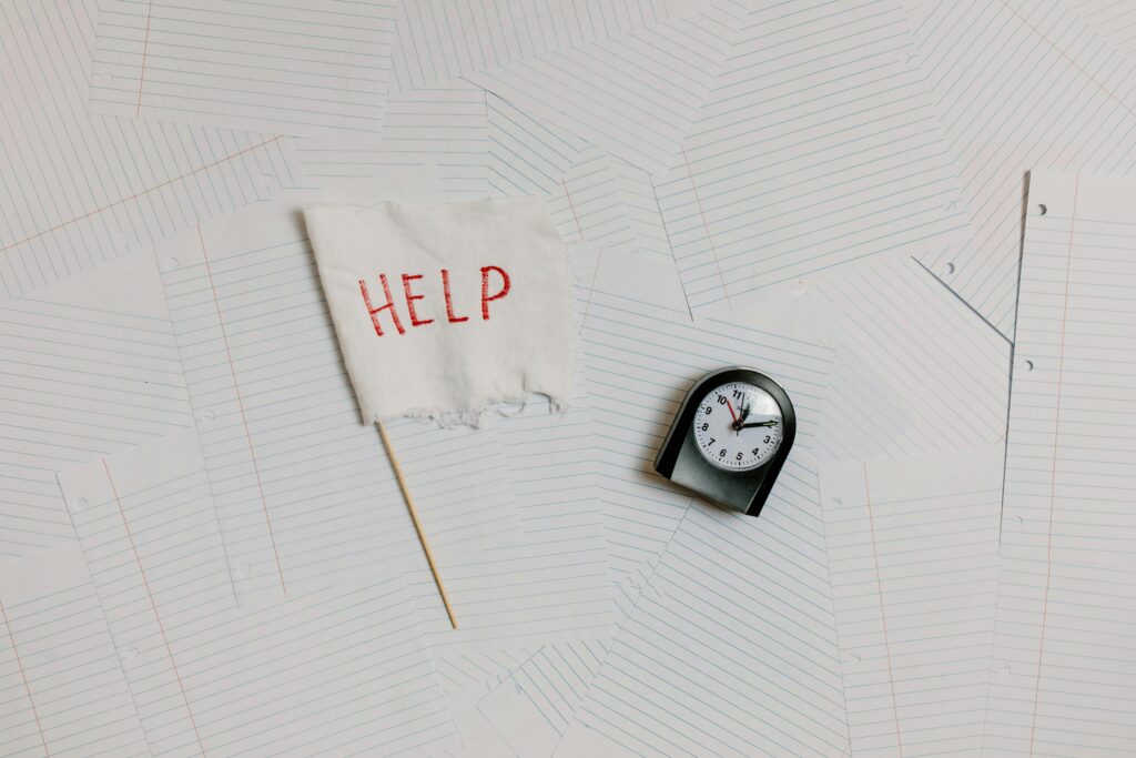 un drapeau blanc avec le mot HELP en rouge à côté d'une horloge.