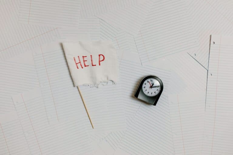 un drapeau blanc avec le mot HELP en rouge à côté d'une horloge.